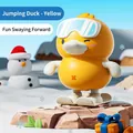 Yellow wind-up jumping duck toy with ski goggles and snowboard in a snowy winter scene - Wind-up Skiing Jumping Duck (Yellow)