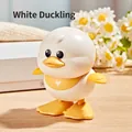 White wind-up duck toy for kids with yellow bib and rolling feet on wooden desk - Wind-up Jumping Duck (White)