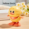 Wind-up yellow duck toy with orange bib and heart pattern on a wooden surface - Wind-up Jumping Duck (Yellow)