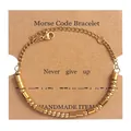 Close-up of golden Morse Code beads on card with Never Give Up inspirational quote - Gold (Never Give Up)