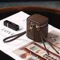 Dunkelkaffeebraune Mini-Kosmetiktasche aus Leder mit goldenem Reißverschluss und Handschlaufe - Braun