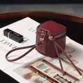 Mini-Geldbörse aus burgunderfarbenem Leder mit Lychee-Muster, Handschlaufe und Goldzipper - Burgunderrot