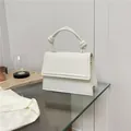 Minimalist white crossbody bag with a unique knotted top handle and a sleek flap design - White