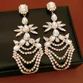 Elegant macro shot of luxury geometric crystal tassel earrings on a black jewelry box - Water Drop Tassel (HE32779) / Gold