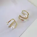 Vista dettagliata di ear cuff dorati con zirconi scintillanti e perle eleganti. - Clip (Singolo) / Oro