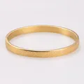 Detail view of a gold-plated stainless steel bangle with unique spotted texture patterns. - 6mm Gold