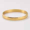 Close-up of a 18K gold plated stainless steel bangle with a unique spotted texture - 8mm Gold