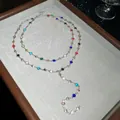 Gros plan d'un collier en Y avec cristaux multicolores et breloques en forme de cœur. - Collier en Y Rond (4#) / Coloré / Argent