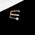 Close-up detail of a three-row gold ear cuff featuring sparkling cubic zirconia and a pearl - Single Piece / Gold