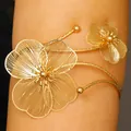 Detail view of adjustable gold filigree flower arm cuff with intricate hollow design - Floral Style (3884) / KC Gold