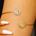 Close-up of adjustable golden shell arm cuffs with intricate engraved shell detail - Shell Style (3883) / KC Gold