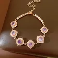 Dettaglio macro di elegante bracciale in oro rosa con fiori di zircone viola scintillanti - Oro rosa - Viola
