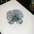 Detailed macro view of a vintage handcrafted light blue crystal beaded flower petal brooch - Elegant Floral / Blue