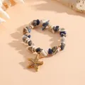 Dettaglio che mostra conchiglie naturali e stella marina con strass su questo braccialetto - Stile T072 Stella Marina Conchiglia Blu (T072) / Blu