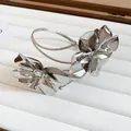 Close-up of metallic flower arm cuff featuring polished silver petals on a white tray - 2# Streamlined 3D Flower / Silver