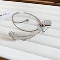 Detailed view of a silver Monstera leaf upper arm cuff on a white jewelry display tray - 1# Monstera Leaf Style / Silver