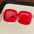 Close-up of square red resin stud earrings with black marbled texture in a jewelry box - Square Studs