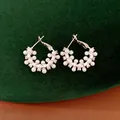 Detailed macro shot of elegant geometric pearl earrings with shimmering zircon - Silver