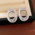 Close-up of elegant oval crossover earrings with baguette-cut cubic zirconia - White
