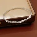 Close-up of a silver stainless steel bangle with inlaid zircons on a luxury jewelry box. - 2# Bracelet-Silver