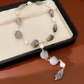 Detailed view of irregular grey marble acrylic and pearl necklace with gold links - Gray