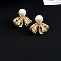 Close-up detail of 18K gold plated lace bow pearl stud earrings with zircon accents. - Lace Bow Knot Style (HE33196) / Gold