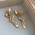 Close-up of elegant gold irregular hollow-out earrings with a unique artistic design - Gold