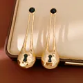 Dettaglio di orecchini in oro martellato con design a toppa e accenti di perline nere - Oro Nero Traforato