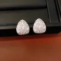 Macro detail of teardrop stud earrings pavé-set with brilliant white cubic zirconia - Silver