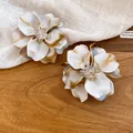 Detailed view of white and brown marble acrylic flower earrings with crystal beads - Silver Needle / Khaki