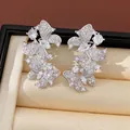 Primo piano di orecchini a farfalla con intarsi in zircone e perni in argento pregiato - Stile con perno dell'orecchino in argento / Argento