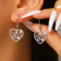 Close-up detail of silver-colored heart-shaped earrings with MaMa script and zircons. - MAMA Heart Earrings (Lips/09-8481)