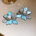 Nahaufnahme eleganter Blumenohrringe mit blauen Blütenblättern und Perlen - Blau