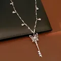 Detailed view of silver butterfly key necklace with flower charms and zircon stone. - Necklace / Silver