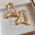 Close-up of vintage hollow triangle metal earrings with a polished glossy gold finish. - Hollow Triangle / Gold