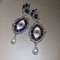Detailed view of ornate evil eye earrings with colorful crystals and pearl drops - Eye Pearl Pendant Style (HE33099) / Gold Multicolor