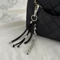 Close-up view of a chic silver metallic bead and black string charm for handbag decor - Silver Beaded Style (00276)