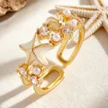 Detalle macro de un anillo abierto dorado con estrella de mar esmaltada, perlas y circonitas. - Anillo Abierto (4147) / Dorado (Estilo Estrella de Mar Concha)