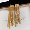 Close-up of gold-plated mesh tassel earrings with shimmering metallic texture. - Asymmetrical Tassel (HE33161) / Gold