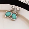 Detail view of French vintage silver drop earrings featuring mint green oval pendants - Green