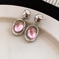 Close-up detail of French vintage pink oval acrylic drop earrings with silver finish - Pink