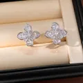 Macro detail of exquisite zircon clover flower ear clips with shiny 18k gold plating - Ear Clip (HE32738) / Silver