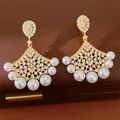 Detailed view of gold-plated fan-shaped earrings with pearls and sparkling zircons. - Gold
