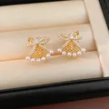 Detailed close-up of gold-plated fan-shaped bowknot clip-on earrings with small pearls - Clip-On Earrings / Gold