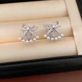 Detailed macro shot of elegant silver-plated bow fan earrings with lattice pearls - Clip-On Earrings / Silver