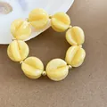 Vista detallada de cuentas de acrílico amarillo en una pulsera de estilo boho. - Pulsera / Amarillo