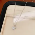 Close-up of elegant zircon cluster pearl pendant necklace on a beige jewelry display tray - Single Necklace / Silver