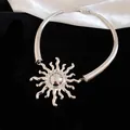 Primo piano di un girocollo in metallo argentato con un ciondolo a forma di sole unico - Argento