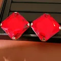Macro detail of square red gemstone stud earrings with facets and silver prongs - Silver Needle Studs / Silver-Red