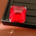 Macro detail of square red gemstone stud earring on a black display tray - Ring / Silver-Red